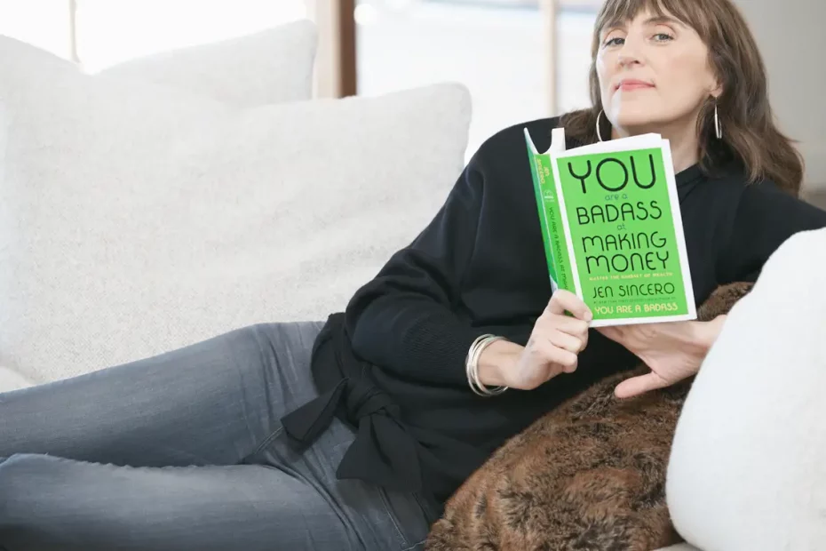 Jen Sincero holding her book You Are A Badass At Making Money